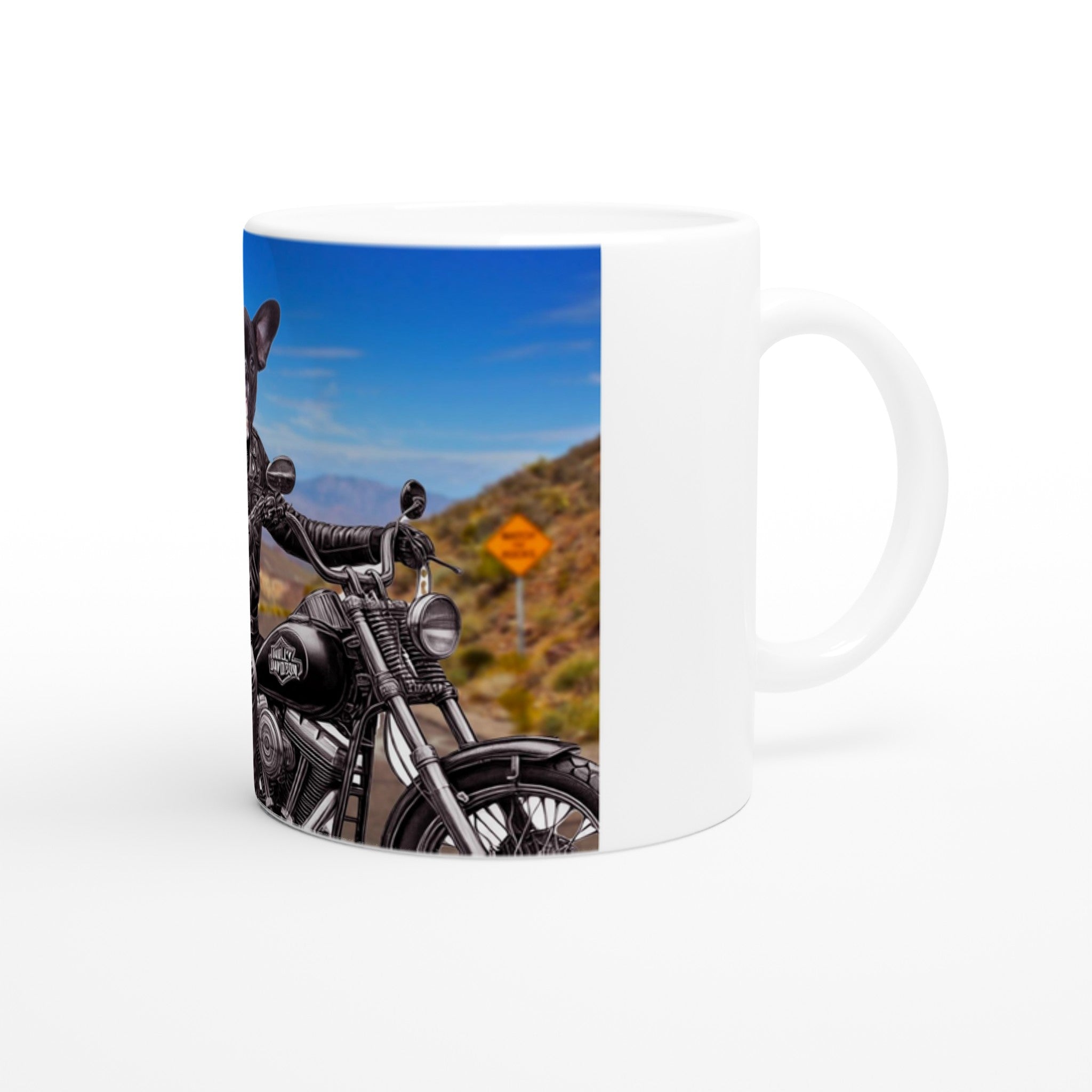 Mug blanc illustré d’un bouledogue français en blouson de cuir et lunettes de soleil, au guidon d’une moto Harley-Davidson sur une route déserte en paysage désertique et montagneux.