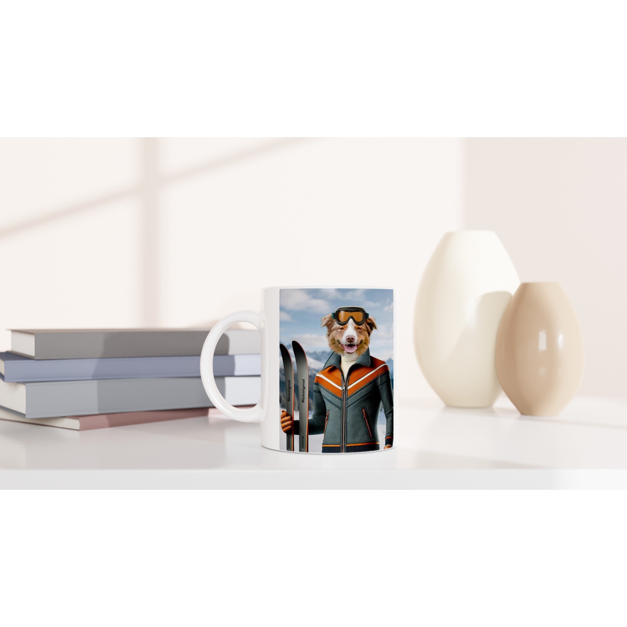 Tasse blanche posée sur un bureau moderne, imprimée d’un chien skieur souriant en veste orange et grise avec des skis, à côté de livres empilés et de vases décoratifs.