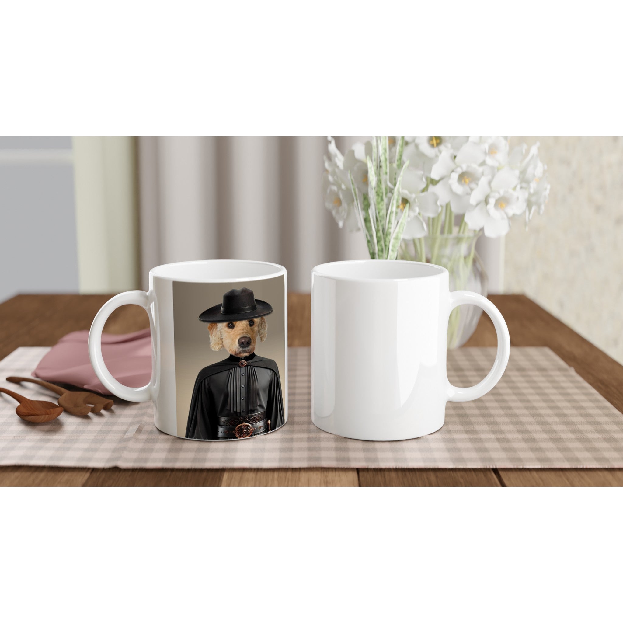 Mugs blancs sur table en bois et nappe vichy, l’un imprimé d’un golden retriever en tenue noire et chapeau, vase de fleurs blanches en arrière-plan