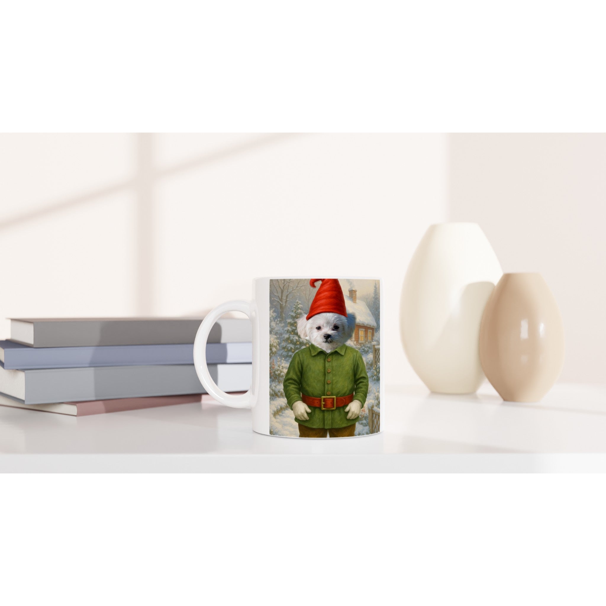 Mug blanc posé sur un bureau, imprimé d’un petit chien blanc déguisé en lutin (veste verte, ceinture et bonnet rouges) devant un paysage hivernal enneigé, avec des livres et deux vases en arrière-plan.