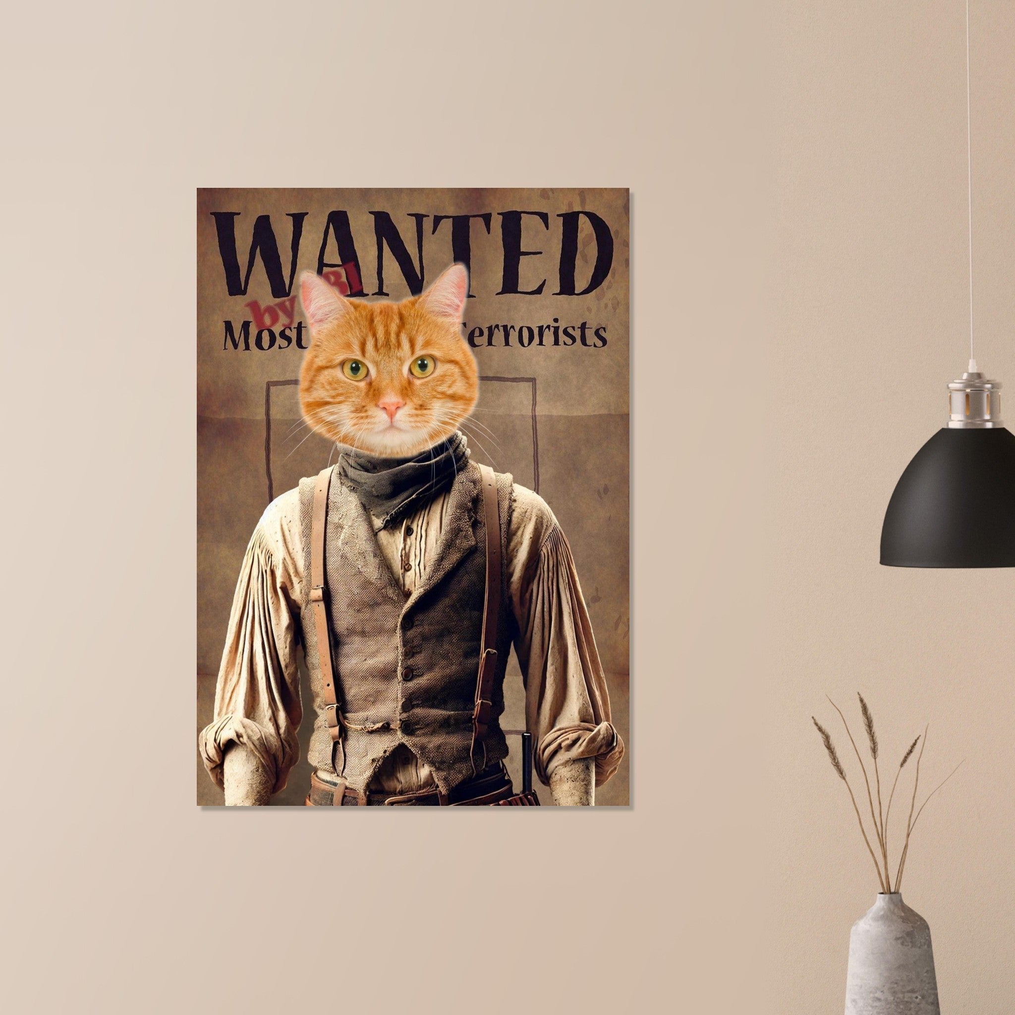 Affiche murale western représentant un chat roux en costume d’outlaw vintage avec l’inscription “WANTED by Most Terrorists”, accrochée sur un mur beige à côté d’une lampe noire suspendue et d’un vase de branchages séchés.