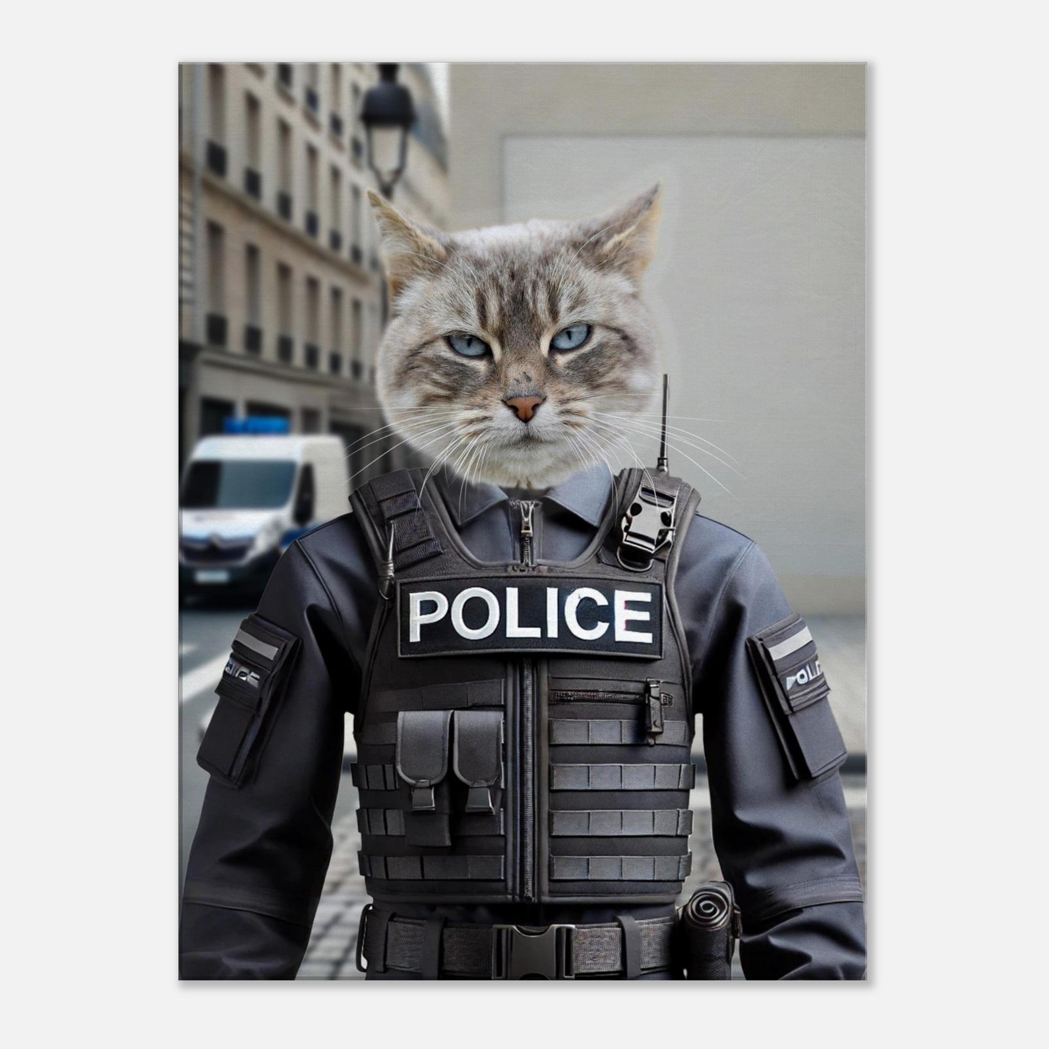 Chat gris aux yeux bleus portant un gilet pare-balles tactique « POLICE » devant une rue urbaine avec un véhicule de police stationné en arrière-plan.