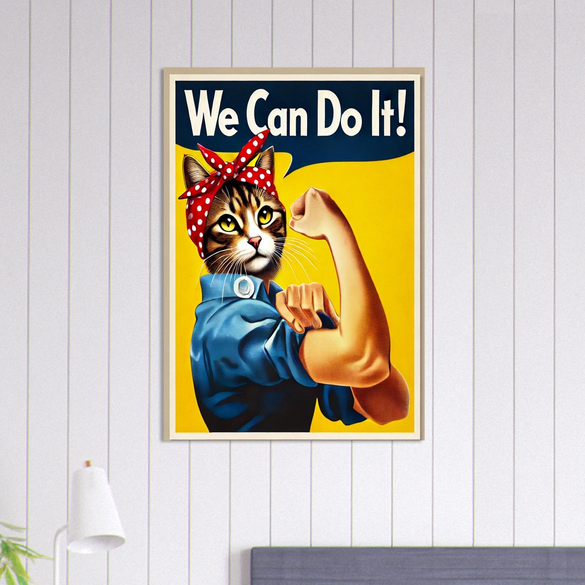 Chat anthropomorphe façon “Rosie la riveteuse” portant un bandana rouge à pois blancs et une chemise bleue, bras musclé levé sous le slogan “We Can Do It!” sur fond jaune.