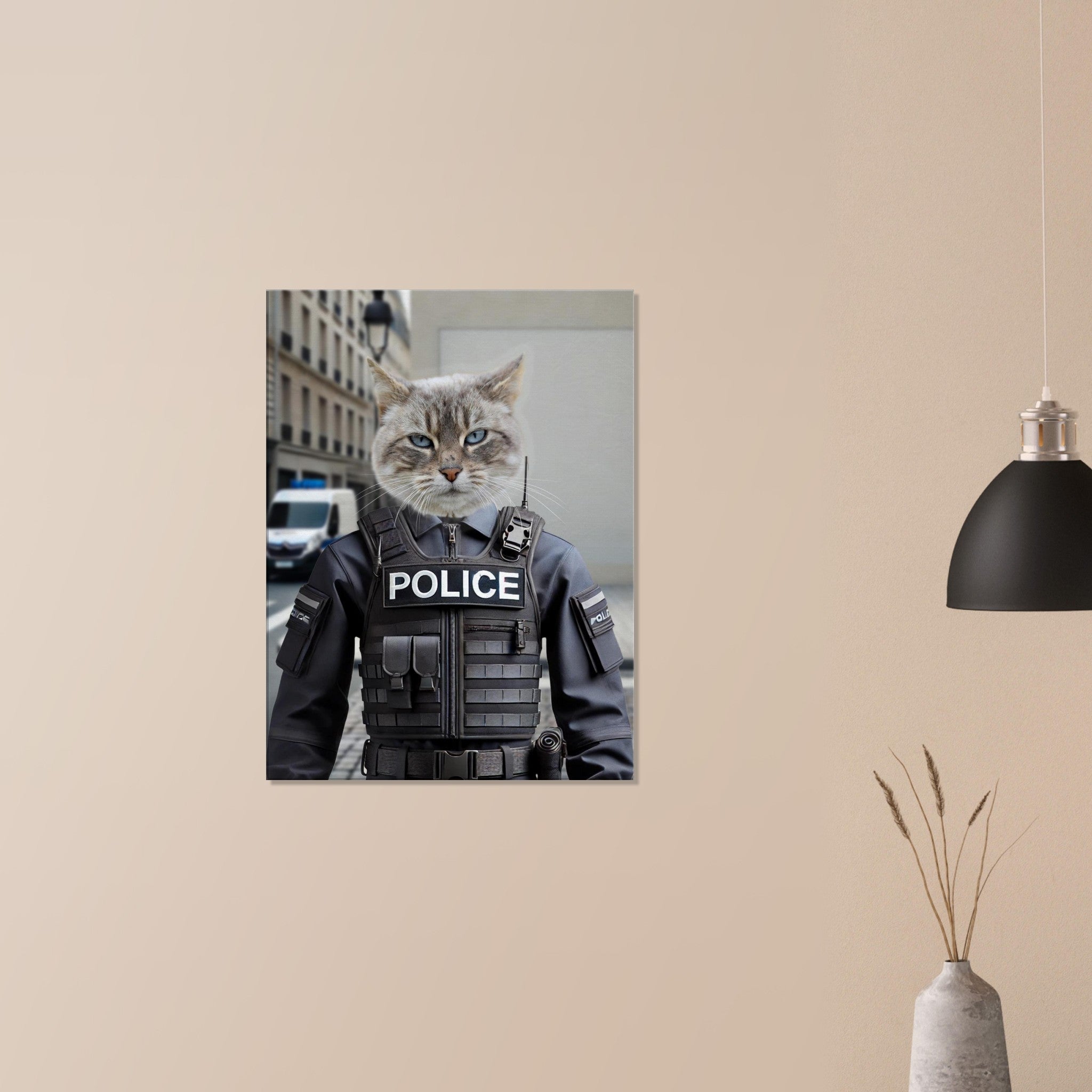 Poster mural représentant un chat au visage réaliste portant un gilet tactique noir « POLICE », accroché sur un mur beige épuré à côté d’une lampe suspendue et d’un vase décoratif.