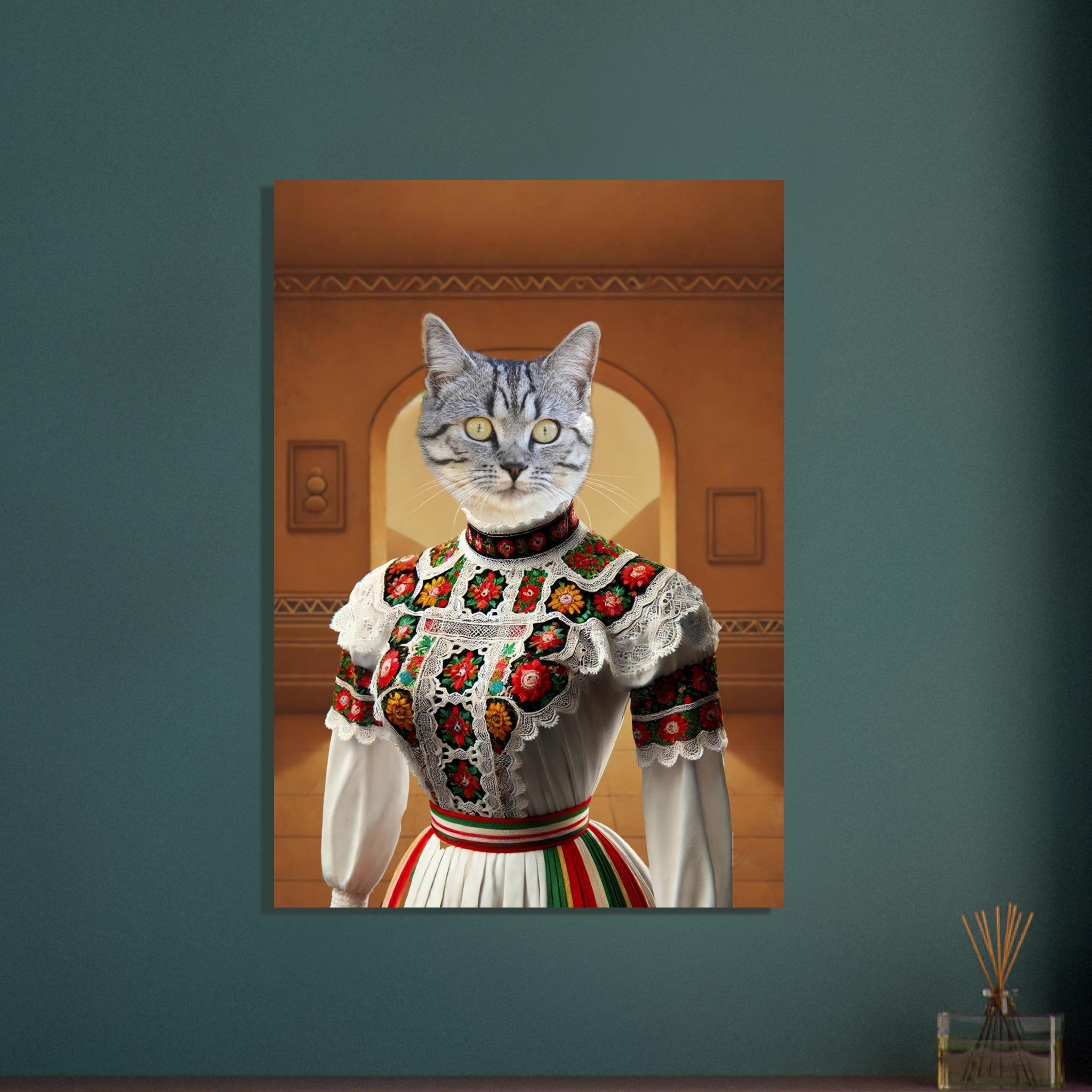 Portrait surréaliste d’un chat tigré vêtu d’une robe folklorique blanche richement brodée de motifs floraux rouges, verts et jaunes, posé devant un mur ocre avec une arche.
