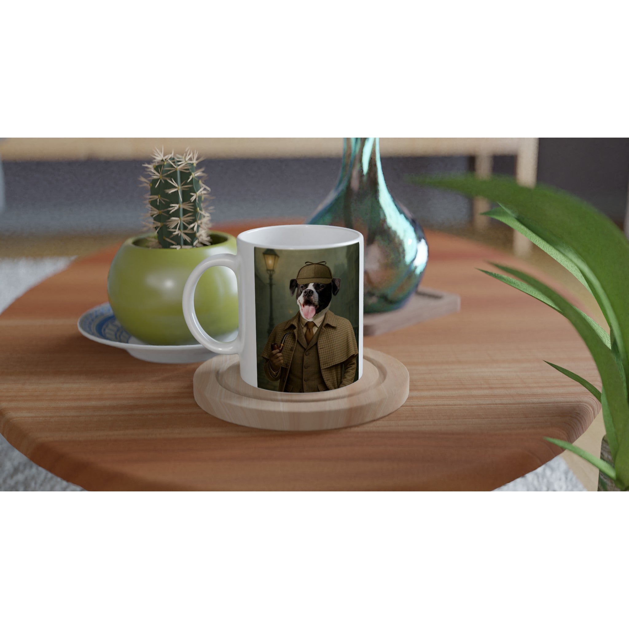 Mug blanc posé sur une table en bois imprimé d’un chien détective façon Sherlock Holmes (chapeau deerstalker, manteau en tweed et pipe), à côté d’un cactus en pot vert et d’un vase en verre bleuté