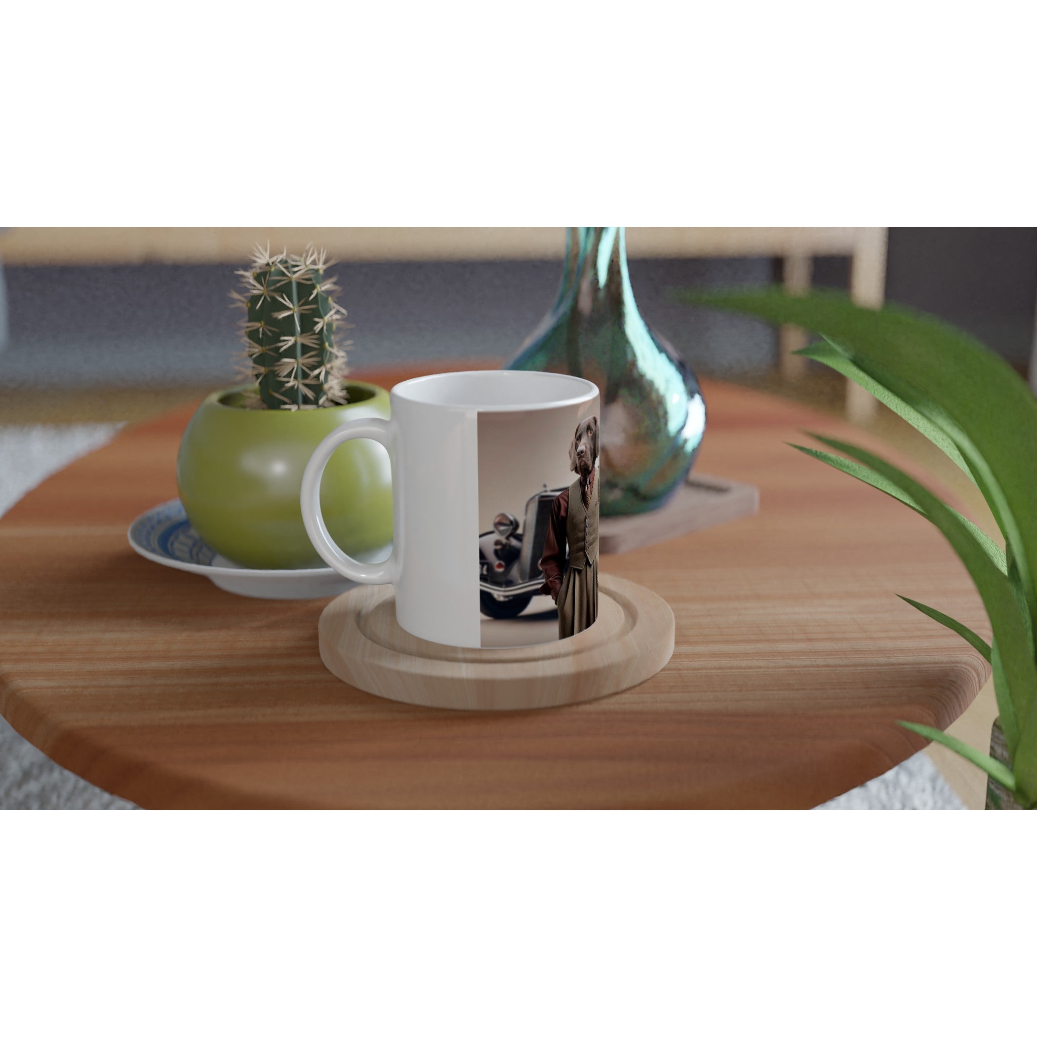 Mug blanc avec impression d’un chien en costume à côté d’une voiture vintage, posé sur un dessous-de-verre en bois sur une table basse, entouré d’un pot de cactus et d’un vase.