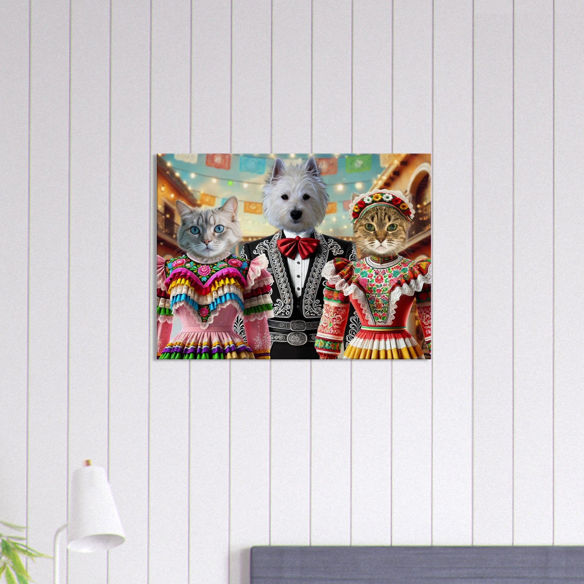 Deux chats vêtus de robes folkloriques mexicaines colorées à volants et motifs floraux, flanquent un petit chien blanc en costume de charro noir et nœud papillon rouge, sous des guirlandes de papel picado.