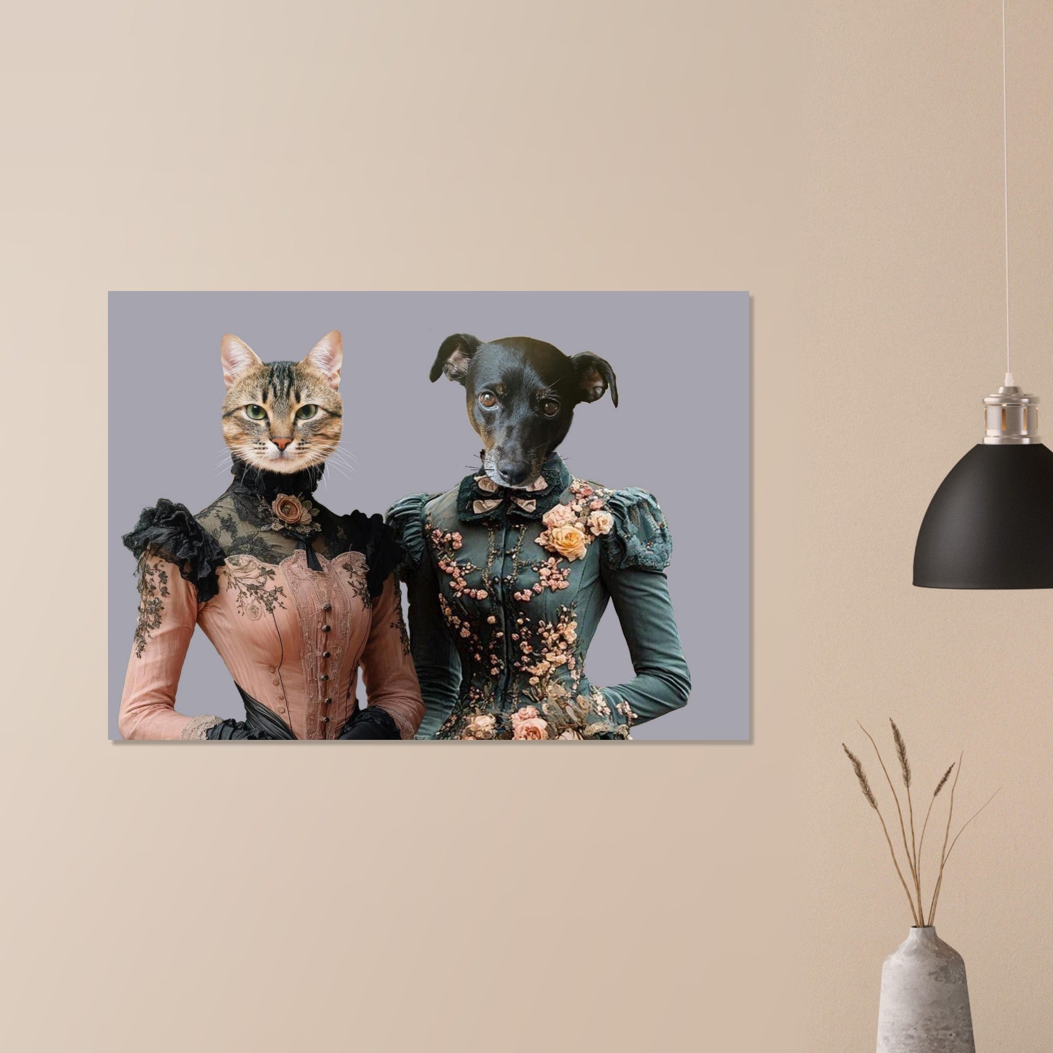 Tableau décoratif sur un mur beige montrant deux silhouettes victorien­nes à tête d’animal : un chat en corset rose à dentelles noires et un petit chien en robe verte richement brodée de fleurs, à côté d’une lampe suspendue noire et d’un vase en céramique aux plantes séchées.