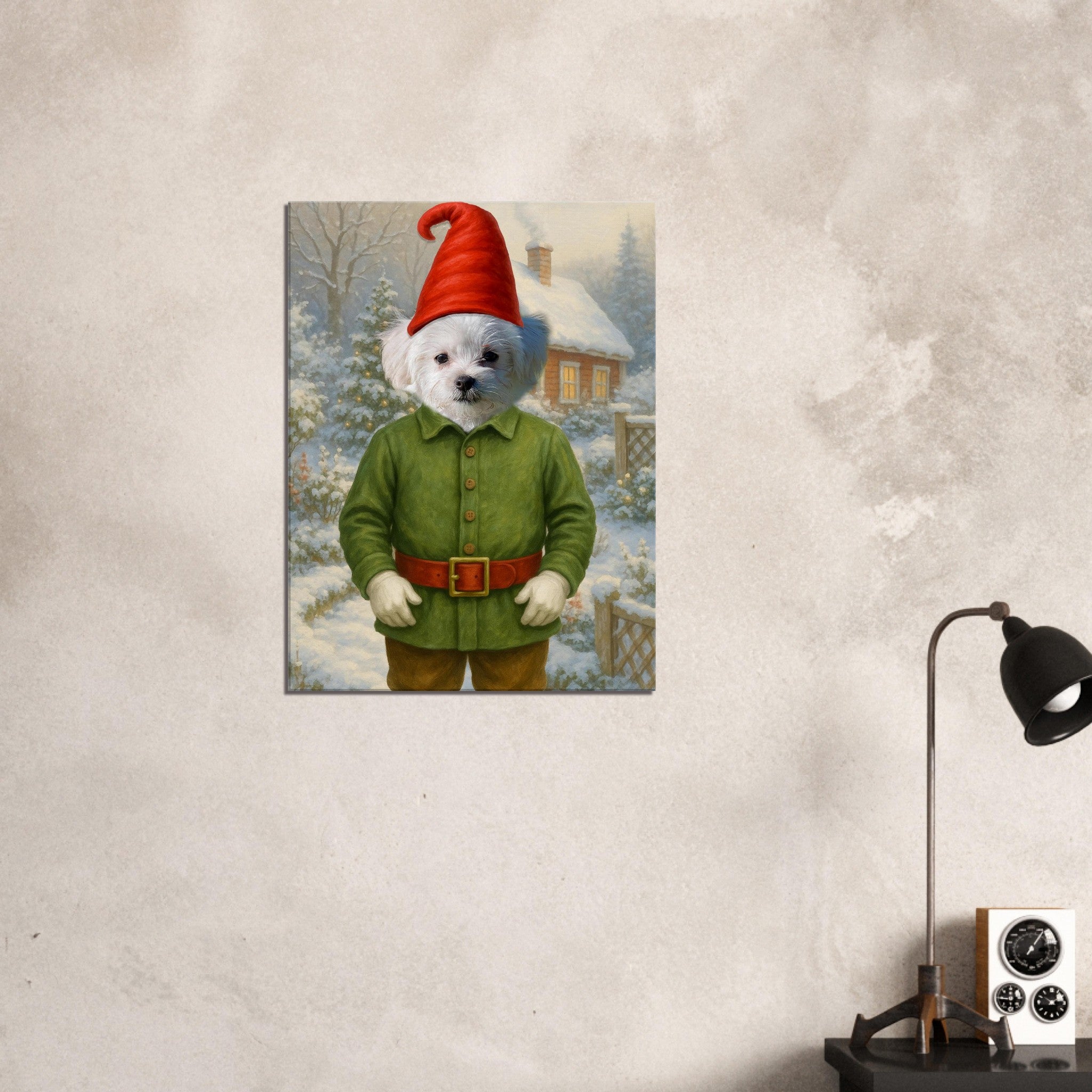 Chien blanc en costume de lutin de Noël (veste verte, ceinture et bonnet rouges) devant un jardin enneigé et une maison aux fenêtres éclairées.