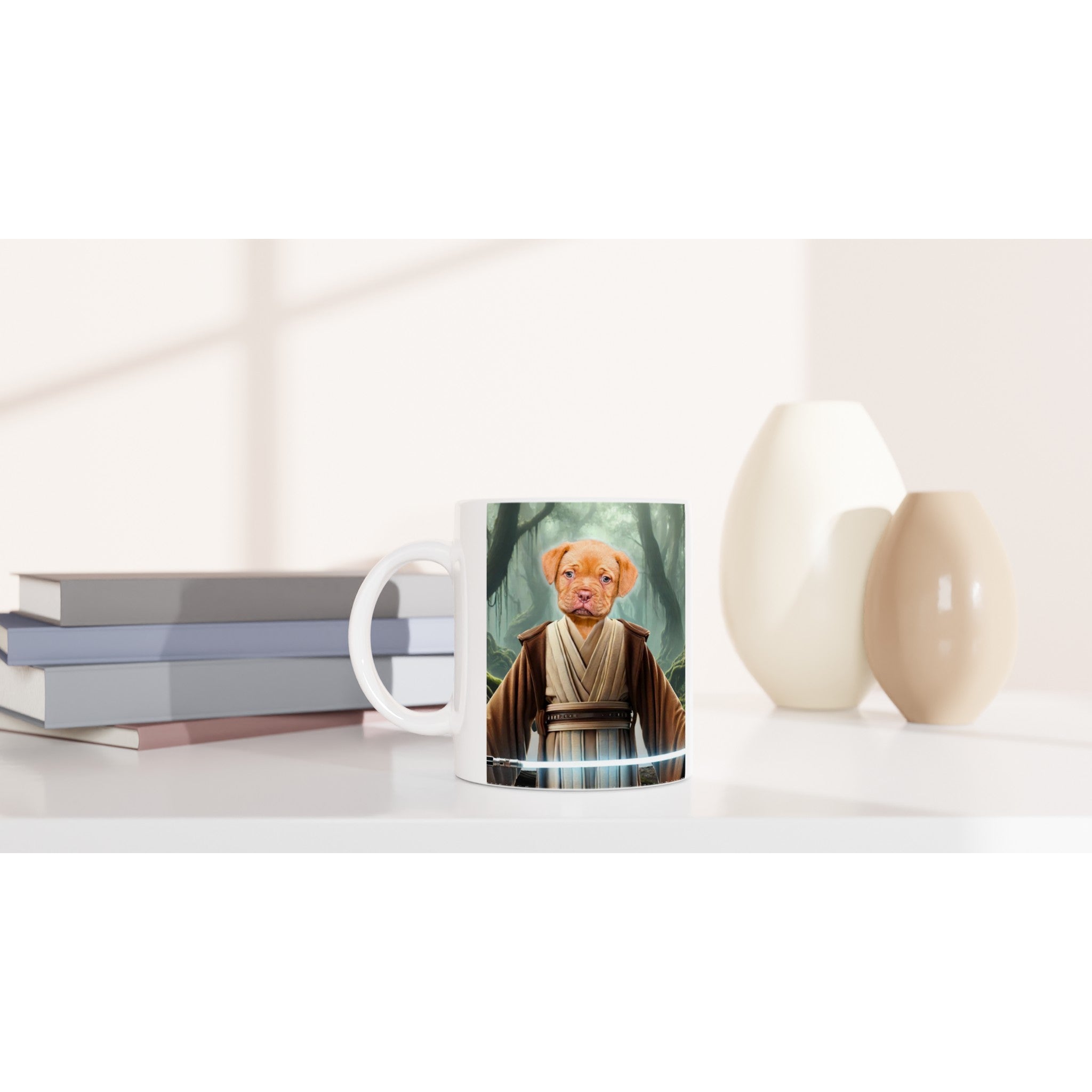 Mug blanc posé sur un bureau à côté d’une pile de livres et de vases, imprimé d’un chiot habillé en tenue de Jedi brandissant un sabre laser bleu devant une forêt brumeuse.