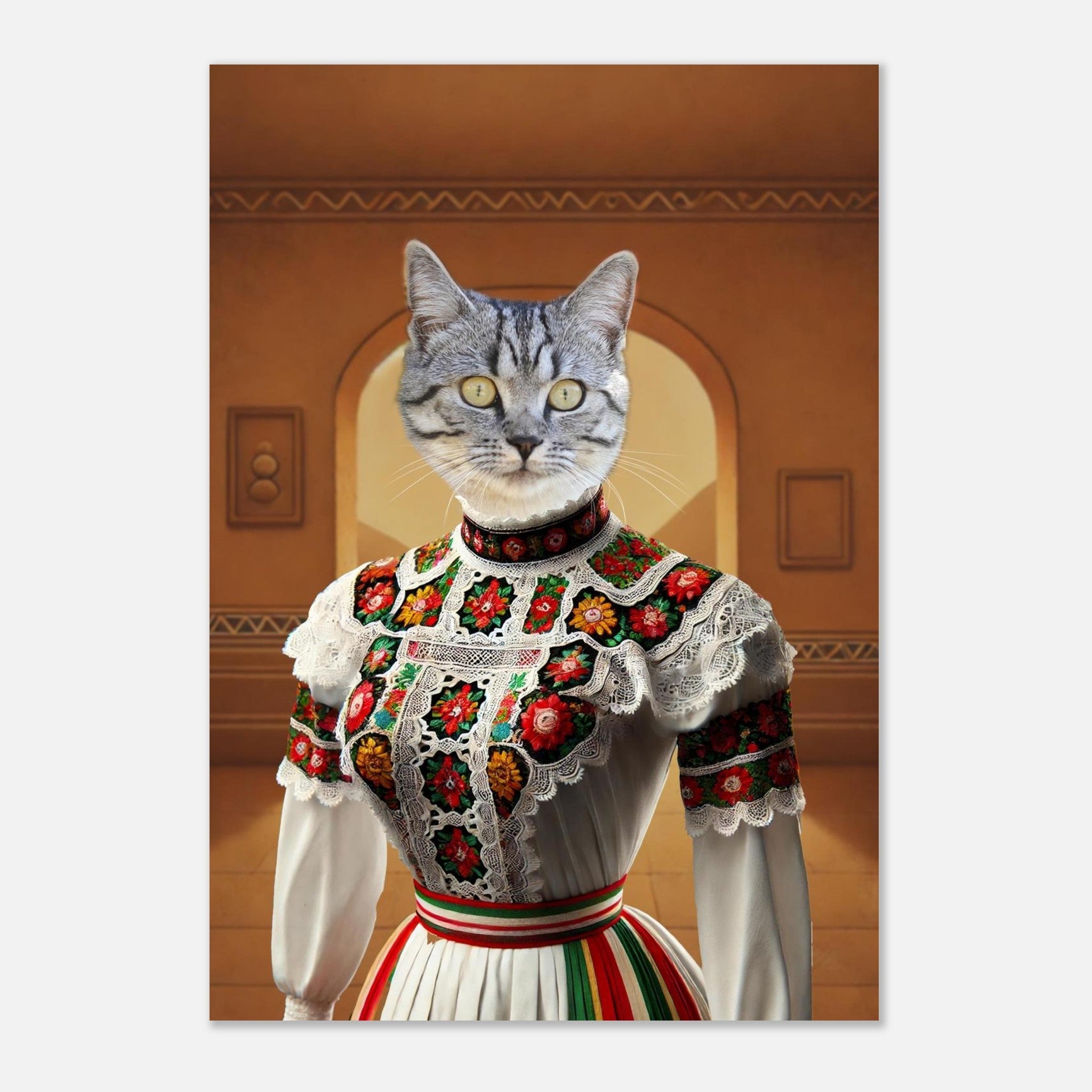 Chat gris aux yeux jaunes en costume folklorique blanc orné de broderies florales rouges, vertes et jaunes et de dentelle, sur fond d’arcades.